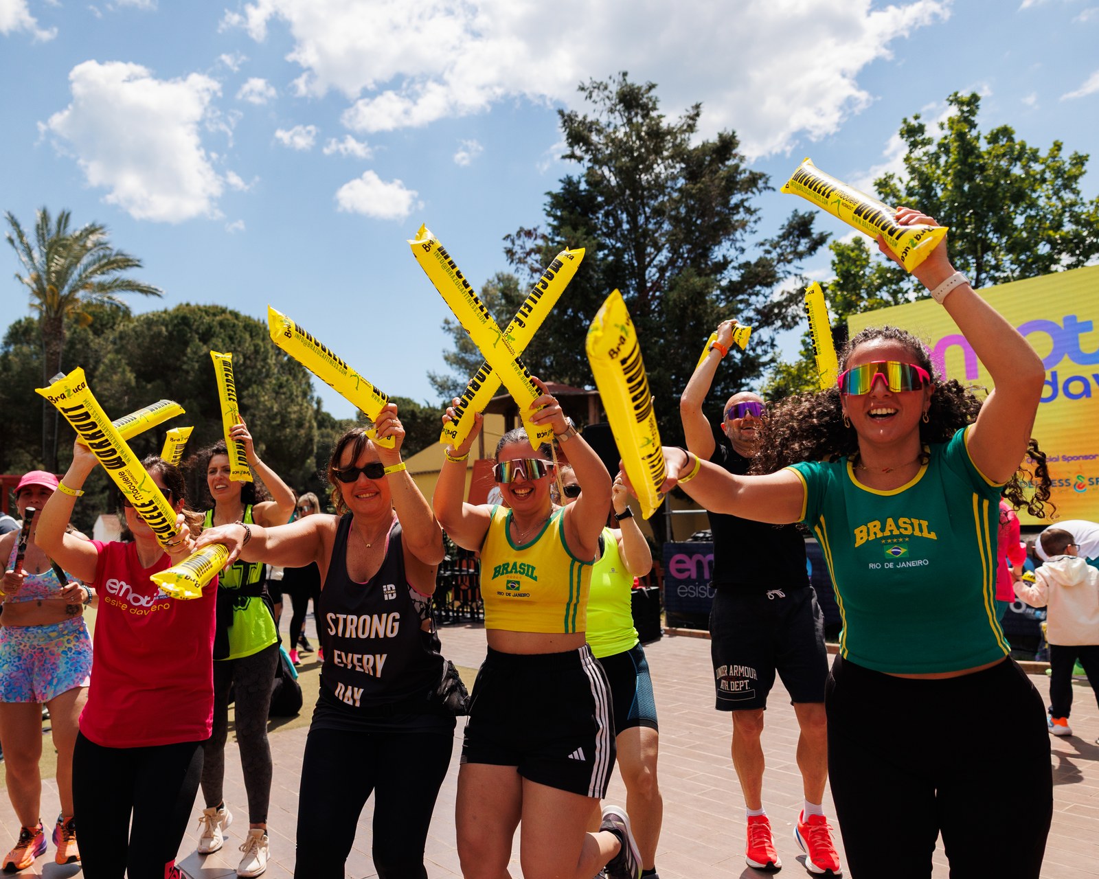 Emotion Fitness — Participants raising training batons above the crowd